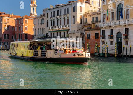 Ein Vaporetto- oder Wasserbus voller Passagiere fährt entlang des Canal Grande in Venedig, Italien Stockfoto