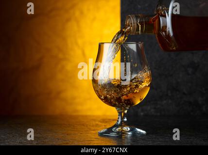 Schnaps aus einer Flasche in ein Glas gießen. Speicherplatz kopieren. Stockfoto