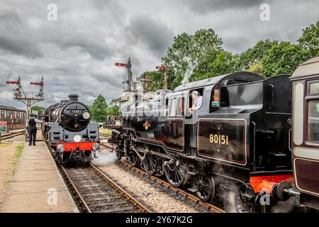 BR '5MT' 4-6-0 No. 73082 'Camelot' passiert BR '4MT' 2-6-4T No. 80151, als es am Bahnhof Horsted Keynes an der Bluebell Railway ankommt Stockfoto