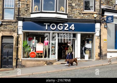 Fashion Storefront von Tog 24 mit Hund und Fußgänger vorbeiziehen. Stockfoto