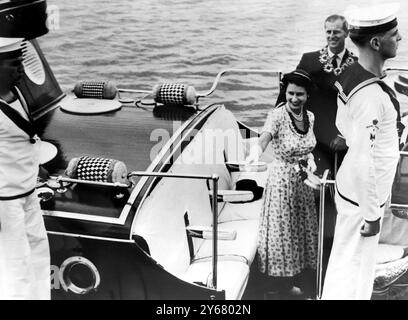 Ein glücklicher Blick auf Königin Elizabeth und den Herzog von Edinburgh in der königlichen Barge nach dem Besuch von Königin Salote von Tonga. Das Königspaar trägt am 28. Dezember 1953 Blumengirlanden, die als Abschiedsgeschenke aus Tonga Nukualofa, Tonga, präsentiert werden Stockfoto