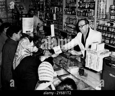 Alfred Bass, ein Lebensmittelhändler aus der Church Street in Greenwich, hat seinen eigenen Krieg gegen die "Tea Giants" begonnen - denn er hat seine Preise um 1/8 T (ca. 8,5 p) pro Pfund gesenkt. Infolgedessen ist sein Geschäft von der Eröffnung bis zur Schließung voll. Die Handelsvereinigung der geschützten Artikel sowie die Teehändler und Produzenten sind sehr wütend - und er wurde gewarnt, dass die Lieferungen an ihn ausgesetzt werden, wenn er seinen Sparpreiskrieg fortsetzt. Aber dieses Bild, das heute Nachmittag aufgenommen wurde, zeigt, dass er sich keine Sorgen macht - und solange der Kunde bedient werden muss, wird er da sein. - 12. Februar Stockfoto