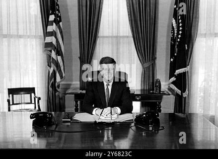 Präsident John Fitzgerald Kennedy sitzt am 21. Januar an seinem Schreibtisch im Weißen Haus und beginnt seinen ersten Arbeitstag als fünfunddreißigster Präsident der Vereinigten Staaten von Amerika. Mit 43 ist Präsident Kennedy der jüngste, der jemals gewählt wurde. In der gestrigen Antrittsrede sagte er den Menschenmassen: "Lasst den Rest der Welt wissen, dass diese Hemisphäre beabsichtigt, Meister in ihrem eigenen Haus zu bleiben." Januar 1961 Stockfoto