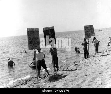 Spanische Werbespots Gott sei Dank gehen die Briten nicht so weit wie die Spanier und bewerben ihre Waren und Veranstaltungen am Strand - denn wenn Sie nach Spanien reisen, werden Sie diese Dinge mit großer Wahrscheinlichkeit sehen. Die Männer laufen den ganzen Tag über den Sand hinauf und hinunter (das waren Werbung Nachtclubs und ihre Animateure) und das Foto wurde in Lloret de Mar an der Costa Brava gemacht. September 1959 Stockfoto