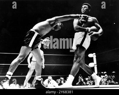 Challenger Floyd Patterson (links) streckt sich aus, um den druel-Koloss des Boxens Cassius Clay in der 9. Runde ihres Schwergewichtskampfes in Las Vegas, Nevada, zu knacken, in dem Clay nach einem technischen Knock-out in der 12. Runde den Titel behielt. November 1965. Stockfoto