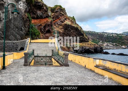 Treppe auf dem erhöhten Ponton zwischen den Lavasteinen des Hafens von Ponta do Sol am Atlantischen Ozean in Madeira Portugal Stockfoto