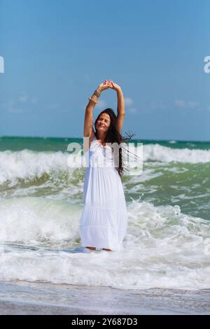 Reife Frau genießt einen gemütlichen Spaziergang am Meer Stockfoto