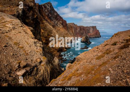 Panorama des Ponta de Sao Lourenco-Vorgebirges zwischen Lavabergen und sonnenverbrannten Wiesen mit Wellen, die auf Lavasteinklippen in Madeira Portugal stürzen Stockfoto