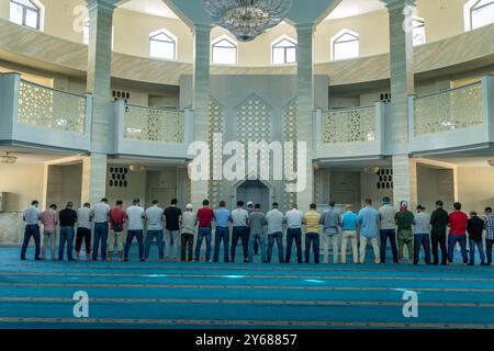 Die Gruppe muslimischer Männer betet in der Großen Moschee von Maykop, Adygea Republik im Nordkaukasus, Russland. Stockfoto