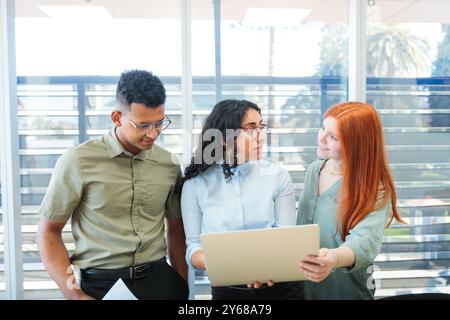 Vorderansicht des jungen Multi-Ethnic Business Teams, das in einem hellen Konferenzraum an einem kreativen Projekt arbeitet Stockfoto