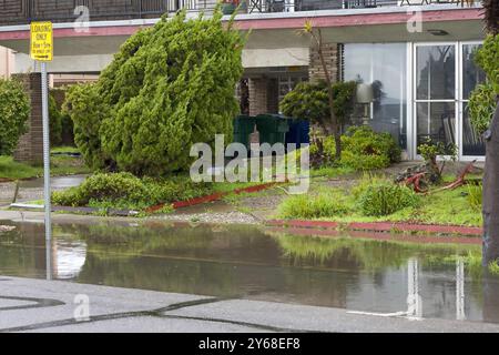 Bürgersteig und Straßenseite mit stehendem Wasser, überflutet nach starkem Regen. Gestörte Wohninfrastruktur. Stockfoto