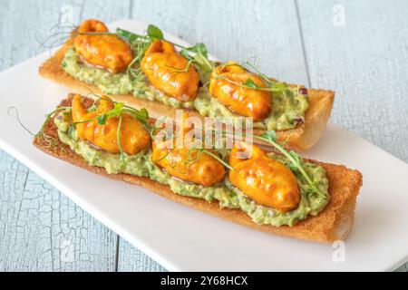 Toast mit Avocado-Guacamole und Krabbenkrallen Stockfoto