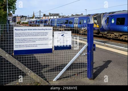 Schild mit Warnung für Passagiere, die vor dem Einsteigen in den Zug am Bahnsteig Largs, North Ayrshire, Schottland, Großbritannien, Europa, ein Ticket kaufen müssen Stockfoto
