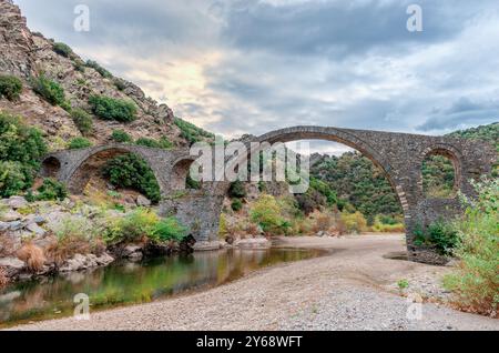 Die dreibogige osmanische Brücke von Polyanthos, die den Kompsatos-Fluss überspannt, der aus dem bergigen Rodopi stammt. In Thrakien, Griechenland Stockfoto