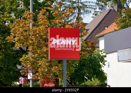 München, Bayern, Deutschland - 23. September 2024: Schild mit rotem Logo des Lebensmittelsupermarktes und Discounter des REWE Group PENNYS in München Obermenzing *** Schild mit rotem Logo vom Lebensmittel Supermarkt und Discounter der REWE-Group PENNY in München Obermenzing Stockfoto