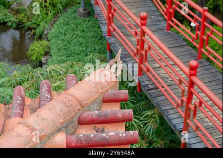 Lebhafte rote Brücke und rustikale Dachdetails in üppigen monte Palace Gärten Stockfoto