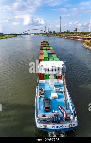 Das niederländische Frachtschiff Vrido, beladen mit Containern, auf dem Rhein bei Duisburg, Talfahrt, hinten die s.g. Brücke der Solidarität über den Rhein, bei Duisburg-Rheinhausen, NRW, Deutschland Container Frachter *** das niederländische Frachtschiff Vrido, beladen mit Containern, auf dem Rhein bei Duisburg, flussabwärts, hinter der s g Brücke der Solidarität über den Rhein, bei Duisburg Rheinhausen, NRW, Deutschland Containerfrachter Stockfoto