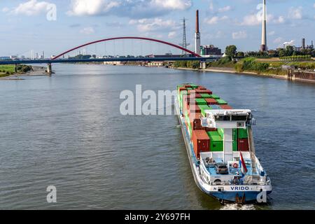 Das niederländische Frachtschiff Vrido, beladen mit Containern, auf dem Rhein bei Duisburg, Talfahrt, hinten die s.g. Brücke der Solidarität über den Rhein, bei Duisburg-Rheinhausen, NRW, Deutschland Container Frachter *** das niederländische Frachtschiff Vrido, beladen mit Containern, auf dem Rhein bei Duisburg, flussabwärts, hinter der s g Brücke der Solidarität über den Rhein, bei Duisburg Rheinhausen, NRW, Deutschland Containerfrachter Stockfoto