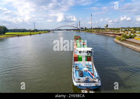 Das niederländische Frachtschiff Vrido, beladen mit Containern, auf dem Rhein bei Duisburg, Talfahrt, hinten die s.g. Brücke der Solidarität über den Rhein, bei Duisburg-Rheinhausen, NRW, Deutschland Container Frachter *** das niederländische Frachtschiff Vrido, beladen mit Containern, auf dem Rhein bei Duisburg, flussabwärts, hinter der s g Brücke der Solidarität über den Rhein, bei Duisburg Rheinhausen, NRW, Deutschland Containerfrachter Stockfoto