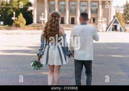 Romantisches Paar, das Hand in Hand in Hand in charmanter urbaner Umgebung schlendert. Stockfoto