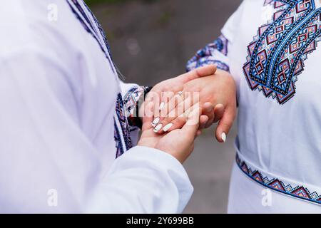 Zarte Momente: Ukrainische Hände in traditioneller Stickerei verflochten. Stockfoto