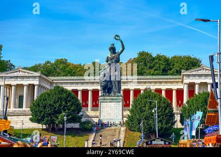 München, Bayern, Deutschland - 23. September 2024: Die monumentale Bayern-Statue am Rande der Theresienwiese in München, umgeben von neoklassizistischer Architektur und Wiesnbesuchern *** die monumentale Bavaria-Statue am Rande der Theresienwiese in München, umgeben von neoklassizistischer Architektur und Wiesnbesuchern Stockfoto