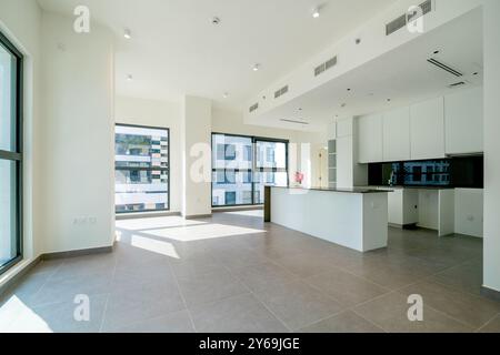 Leeres Wohnzimmer, Fenster, Küche, glänzende Fliesenböden und weiße Wände, Tageslicht Stockfoto