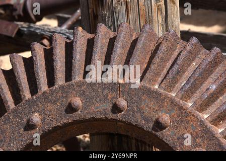 Nahaufnahme des Stahlrads zeigt Zahnräder. Das Rad ist alt und rostbedeckt. Es ist ein Überbleibsel des Bergbaus in New Mexico. Stockfoto