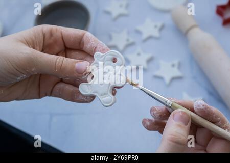 Lebkuchencharakter Meisterklasse der Malerei Kinder lufttrockene Tontätigkeit Handwerksidee. Schritt für Schritt Anleitung zum DIY-Prozess. Vorbereitung auf Weihnachtsbaumschmuck. Modernes Bio-Design, minimalistisches, frei von Kunststoffen, nachhaltiges Dekor Stockfoto