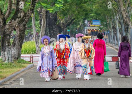 Frauen in traditioneller Kleidung gehen durch den Park in der Zitadelle - Hue Vietnam Stockfoto