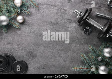 Barbell, Hantelteile und Weihnachtsdekor auf grauem Hintergrund, flache Lagen. Leerzeichen für Text Stockfoto