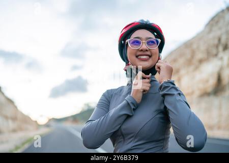 Frau, die Fahrrad fährt und Helm aufsetzt Stockfoto
