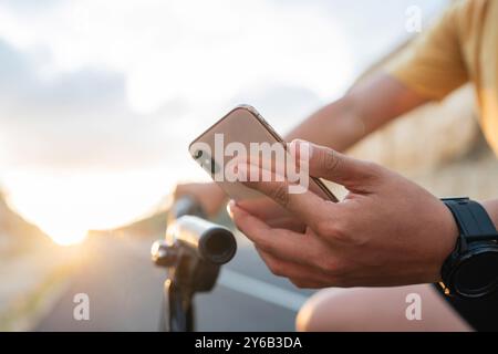 Nahaufnahme männlicher Biker, der das Telefon hält Stockfoto