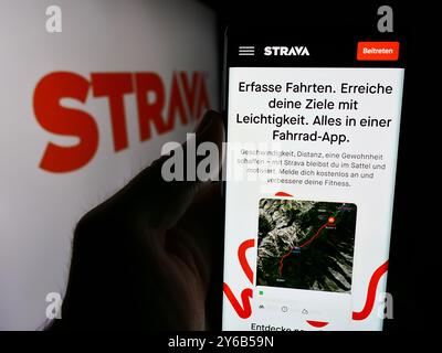 Deutschland. September 2024. In dieser Abbildung hält eine Person ein Smartphone mit der Webseite des US-amerikanischen Fitnessnetzwerks Strava Inc. Vor dem Firmenlogo. Quelle: SOPA Images Limited/Alamy Live News Stockfoto