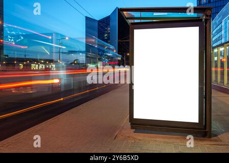 Bushaltestelle Mit Beleuchtetem Leerem Modell Einer Vertikalen Lichtbox Für Ihre Werbung Oder Banner. Public Information Reklametafeln mit unscharfen Lichtstreifen I Stockfoto