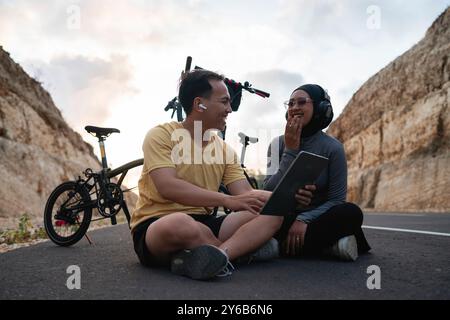 Männlich und weiblich Biker mit Tablette und gemeinsam lachen Stockfoto