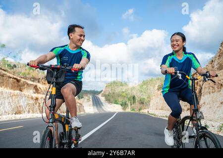 Glückliche weibliche und männliche Athletin, die zusammen Radfahren Stockfoto