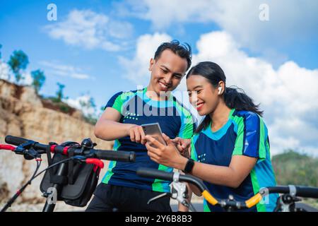 Weibliche und männliche Radfahrer mit Telefon, Fahrrad fahren Stockfoto