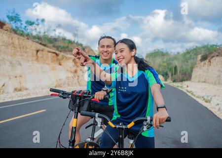 Radfahren mit zeigender Geste für Frauen und Männer Stockfoto