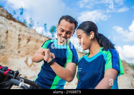 Männlicher Athlet zeigt weibliche Partnerin der digitalen Uhr Stockfoto