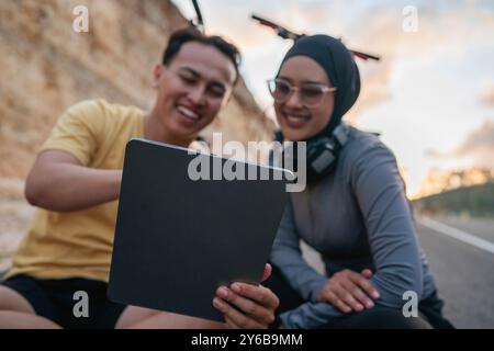 Schließen Sie weibliche und männliche Biker mit der Tablette Stockfoto