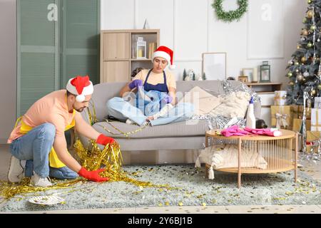 Junge Hausmeister im Weihnachtsmannsputzraum nach der Neujahrsfeier Stockfoto