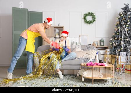 Junge Hausmeister im Weihnachtsmannsputzraum nach der Neujahrsfeier Stockfoto