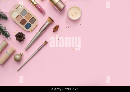 Wunderschöne Weihnachtsdekoration mit verschiedenen Make-up-Produkten auf rosa Hintergrund Stockfoto