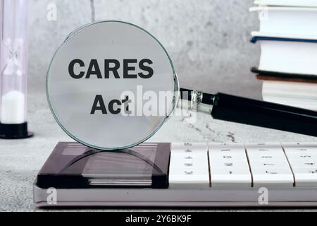 Das Coronavirus Aid, Relief and Economic Security Act. Ein Wort CARES wirkt auf den Hintergrund durch eine vergrößernde gla Stockfoto