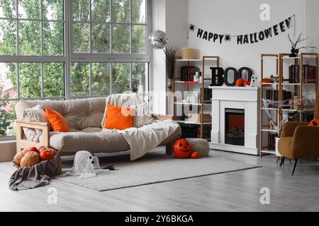 Inneres des Wohnzimmers dekoriert für Halloween mit Sofa, Discoball, Kamin und Kürbissen Stockfoto