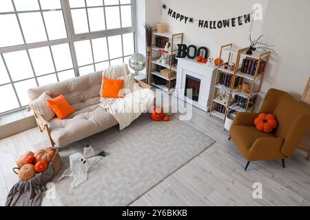 Inneres des Wohnzimmers dekoriert für Halloween mit Sofa, Discoball, Kamin und Kürbissen Stockfoto