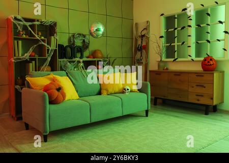 Stilvolles Wohnzimmer mit Diskokugel und weichem Sofa für Halloween-Party in der Nacht Stockfoto