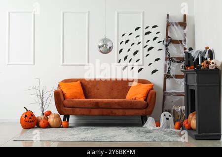 Stilvolles Wohnzimmer mit Diskokugel und braunem Sofa für Halloween-Party Stockfoto