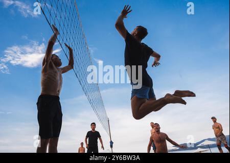 Teams mit multinationalen Spielern spielen im Sommer Beachvolleyball am Strand in Vietnam. Nha Trang, Vietnam - 4. August 2024 Stockfoto